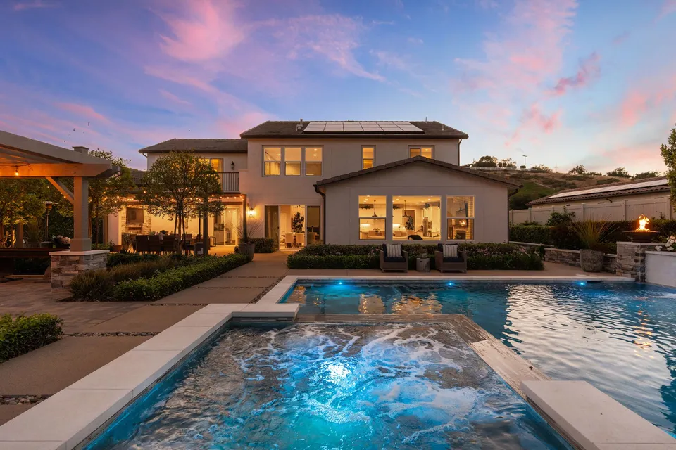 Pool and spa behind the home at dusk