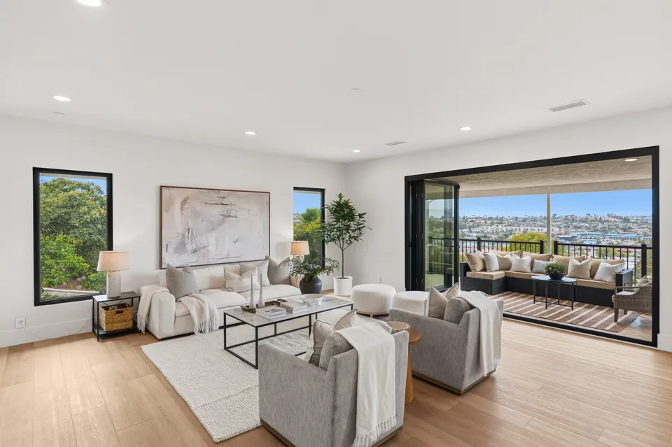 Living room open to a covered balcony with lake views