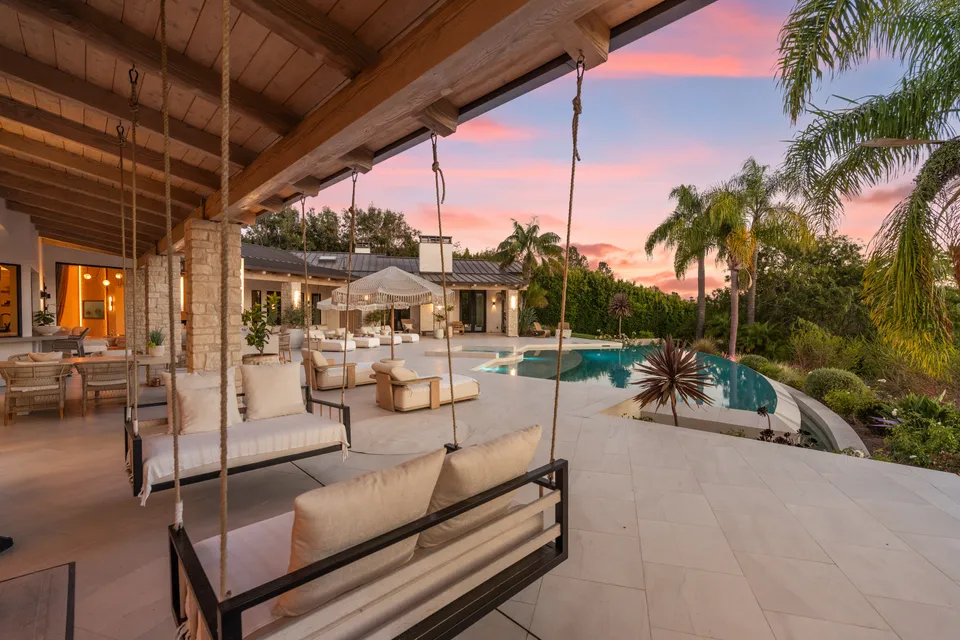 Covered porch with hanging daybeds above the pool