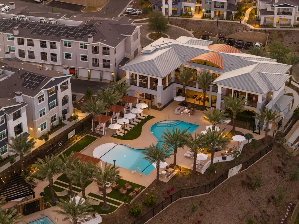 Aerial photo of the clubhouse and pools at dusk